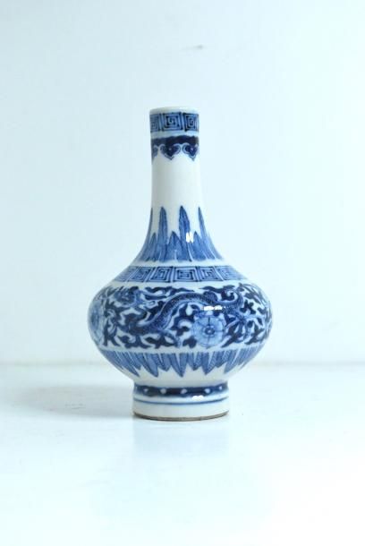null Chine. Petit vase soliflore en porcelaine à décor bleu et blanc de deux dragons...