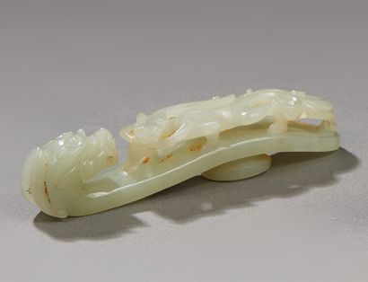 CHINE Fibule Daïku en jade clair sculpté d'un kilin affronté à une tête de chimère.
XXe...