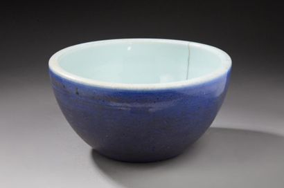 CHINE Grande coupe circulaire en porcelaine à fond bleu poudré sur lequel on aperçoit...