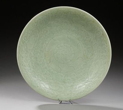CHINE Plat circulaire en porcelaine à couverte céladon verte à décor moulé de fleurs...