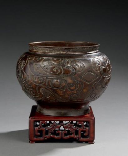 CHINE Vase funéraire en bronze à patine brune, réhaussé d'or, de formes balustres...