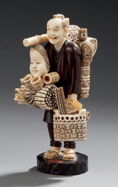 JAPON Okimono en ivoire et bois sculpté représentant un vendeur ambulant de vanneries,...