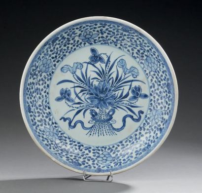 CHINE Plat circulaire en porcelaine, décoré en bleu sous-couverte d'un bouquet de...