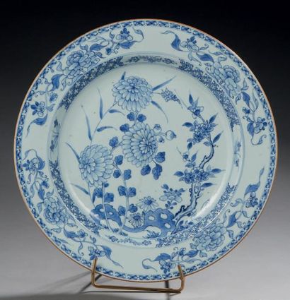 CHINE Grand plat ciruclaire en porcelaine, décoré en bleu sous-souverte de pivoines,...