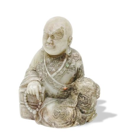 CHINE Figure sculptée en stéatite représentant un moine assis tenant un chapelet...
