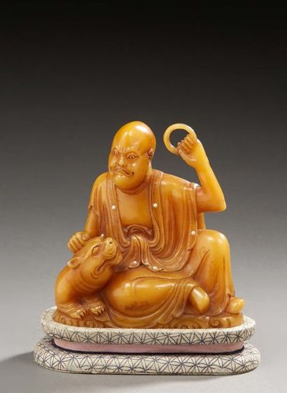CHINE Figurine en stéatite sculptée représentant un ascète caressant un chien Fô...
