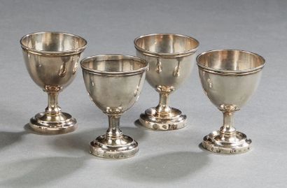 null A series of four plain silver egg cups, resting on a shower base with a doucine,...