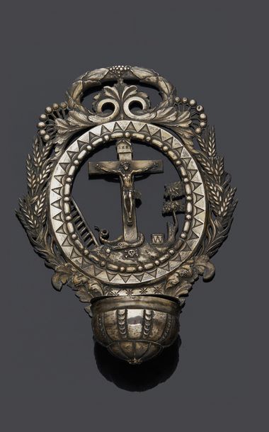 null repoussé silver holy water font made up of a crucifix in an area of grasses...