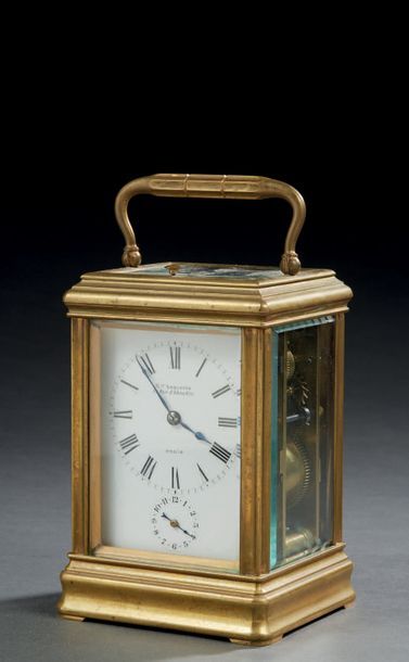 null Polished brass travel cage clock; the dial indicating the hours in Roman numerals...