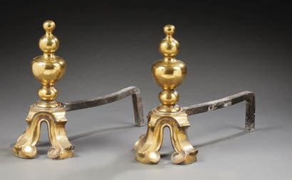 null Pair of polished brass chenets in the shape of turned vases resting on console...