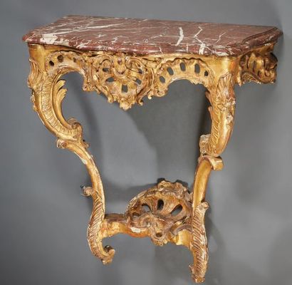 null Console in carved and gilded oak; the belt pierced centred with a shell; double-leafed...