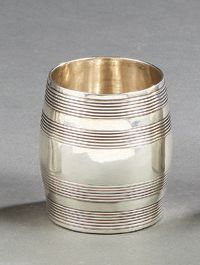 null A plain silver tumbler in the shape of a barrel decorated with large nets simulating...