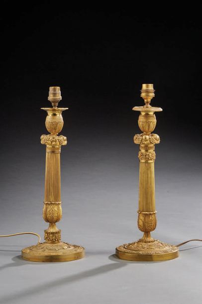 null Pair of large candlesticks in chased or knurled and gilded bronze; the bobèches...