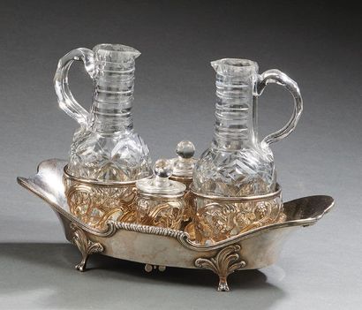 null A silver oil and vinegar basin, resting on four feet with foliage wraps, the...