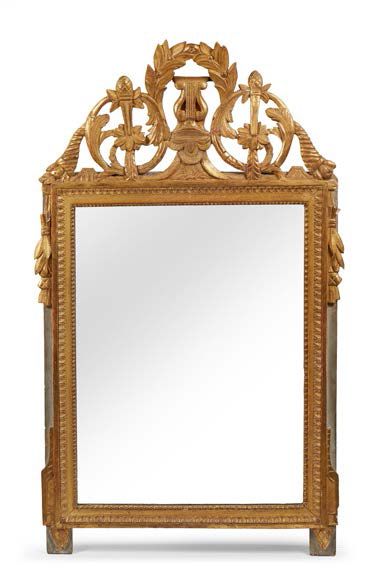 null Miroir dans un cadre en bois sculpté et doré; le fronton centré d'une lyre laurée;...