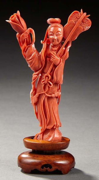 CHINE Branche de corail rose sculpté représentant une Guanyin debout tenant d'une...