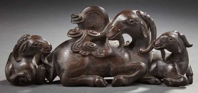 CHINE Groupe en bois exotique sculpté représentant une chèvre et ses chevreaux couchés....