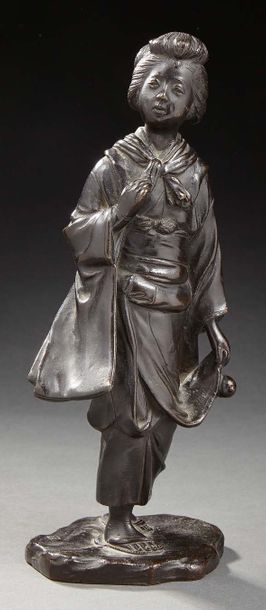 JAPON Figurine en bronze à patine brune représentant une japonaise marchant sur un...