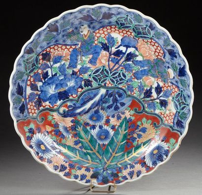 JAPON Grande assiette en porcelaine décoré dans la palette imari de deux personnage...