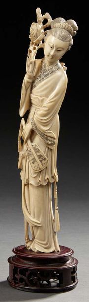 JAPON Okimono en ivoire sculpté représentant une femme debout tenant d'une main un...