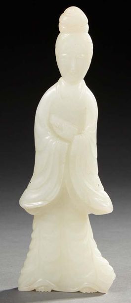 CHINE Figurine en jade clair sculptée représentant une femme tenant d'une main un...