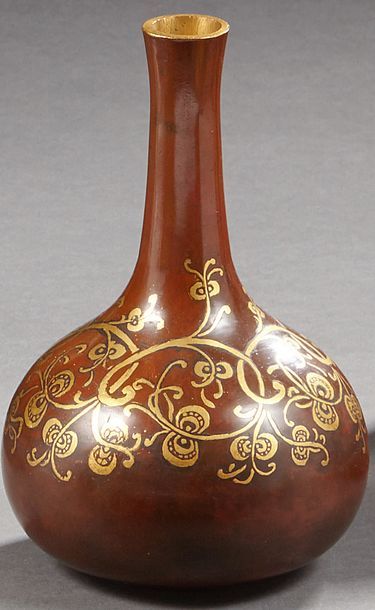 CHRISTOFLE Vase à col en bronze à patine brune décoré de rinceau doré en incrustation.
Début...