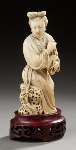 CHINE Figurine en ivoire sculpté représentant une jeune femme assise sur un rocher...