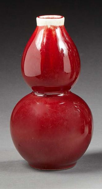CHINE Vase double gourde en porcelaine à décor monochrome flammé rouge.
Au revers...