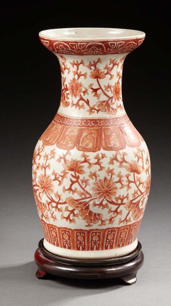 CHINE Vase en porcelaine de forme balustre décorée en rouge de fer de fleurs de lotus....