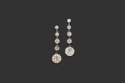 null Pair of platinum earrings each adorned with a half-cut diamond held back by...