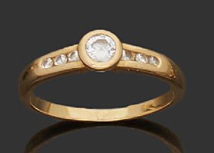 null Bague en or jaune 18K (750) sertie d'un diamant épaulé de trois petits diamants.
Tour...