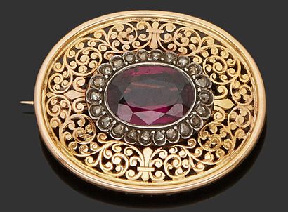 null Oval brooch in 18K (750) yellow gold, openwork and stylized with scrolls decorated...