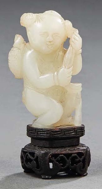 CHINE - Vers 1900 Statuette de garçon debout en néphrite céladon tenant un ruban...
