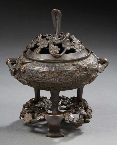 JAPON - Vers 1900 Brûle-parfum tripode en bronze à patine brune à décor de fleurs...