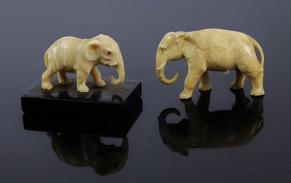 null Deux éléphants en ivoire sculpté aux yeux incrustés, l'un sur une base en marbre...