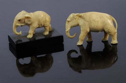 null Deux éléphants en ivoire sculpté aux yeux incrustés, l'un sur une base en marbre...