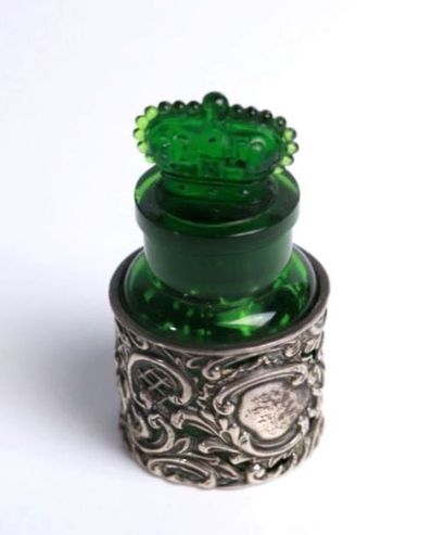 null Green tinted glass bottle in a rococo silver frame.

The cap featuring a closed...