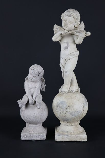 null Deux statuettes en composition patinée figurant des amours sur des sphères reposant...
