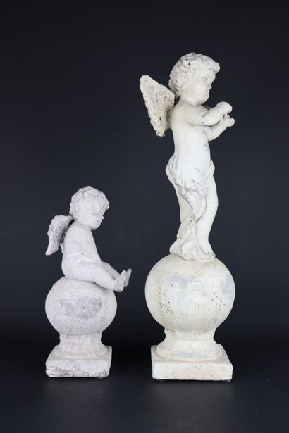 null Deux statuettes en composition patinée figurant des amours sur des sphères reposant...