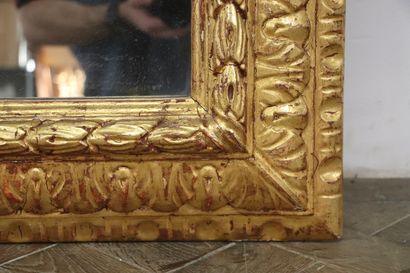 null Miroir à fronton en bois et stuc doré, sommé de deux putti encadrant un médaillon...