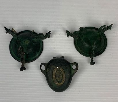 null Ensemble de trois bronzes à patine vert foncé, l'un représentant un masque grimaçant...