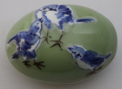 null CHINE.

Deux oeufs couverts en porcelaine à décor d'oiseaux en bleu et brun...