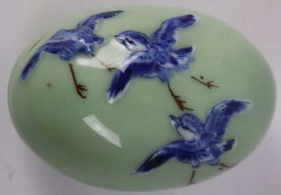 null CHINE.

Deux oeufs couverts en porcelaine à décor d'oiseaux en bleu et brun...