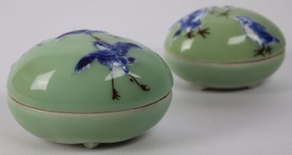 null CHINE.

Deux oeufs couverts en porcelaine à décor d'oiseaux en bleu et brun...