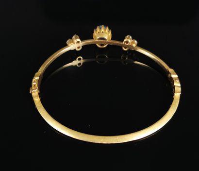 null Bracelet rigide en or jaune orné d'un cabochon de saphir et de six diamants.

L_...