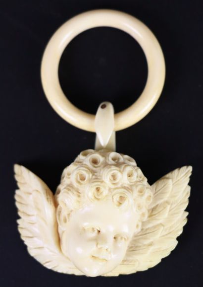 null Elément de berceau en ivoire rsculpté représentant un une tête d'ange. 

Trois...