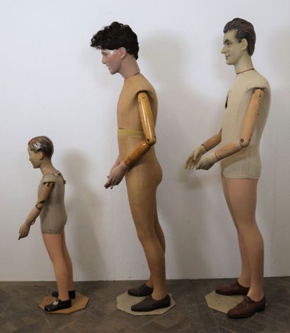 null Trois mannequins de magasin en composition peinte et tissu, les bras en bois...