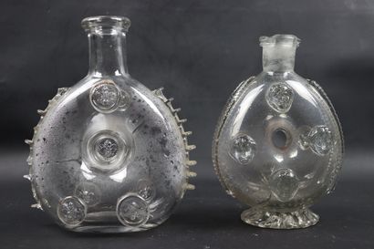 null Two glass bottles, one decorated with faces in application, the other with lily...
