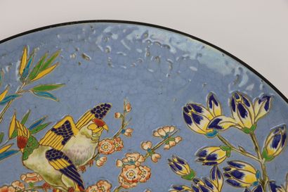 null LONGWY.

Large earthenware dish decorated with polychrome enamels showing parakeets...