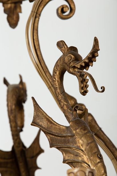 null Lustre en bronze doré à dix bras de lumière, à décor de dragons et feuillages....